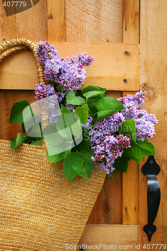 Image of lilacs in a straw purse