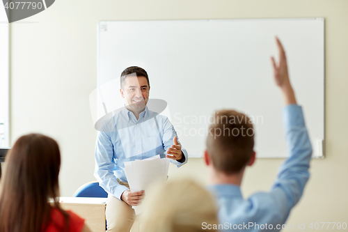 Image of group of students and teacher with papers or tests