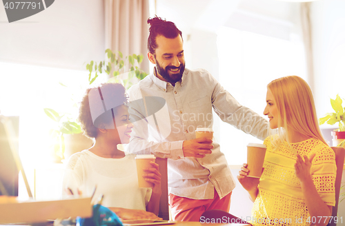 Image of business team with coffee cups talking at office