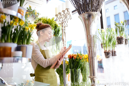 Image of florist woman with clipboard at flower shop