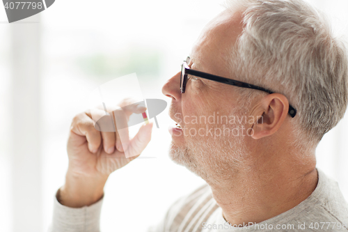 Image of close up of senior man taking medicine pill