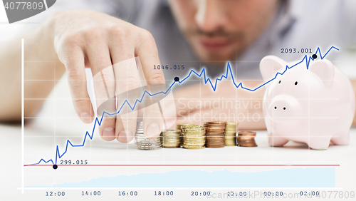 Image of close up of businessman with piggy bank and coins