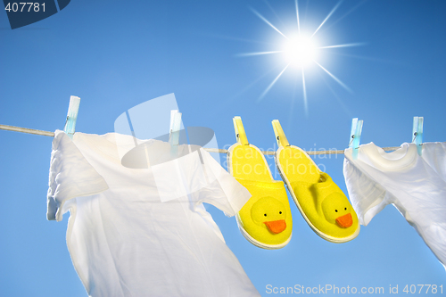 Image of White t-shirts and slippers on the clothesline