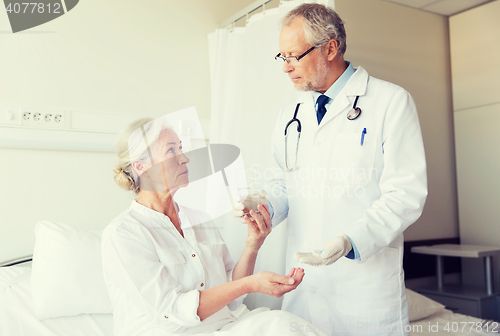 Image of doctor giving medicine to senior woman at hospital