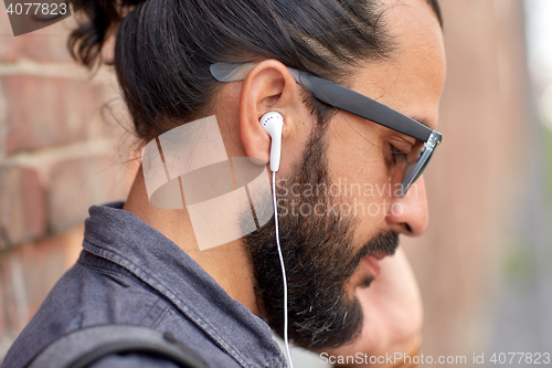 Image of close up of man with earphones listening to music