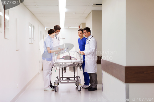 Image of medics with woman on hospital gurney at emergency