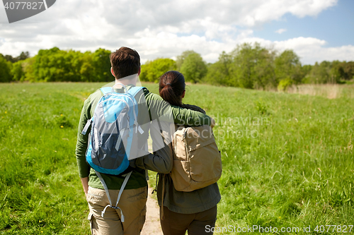 Image of happy couple with backpacks hiking outdoors