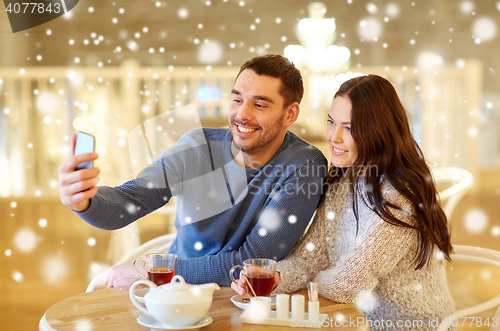 Image of couple taking smartphone selfie at cafe restaurant