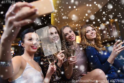 Image of women with champagne taking selfie at night club