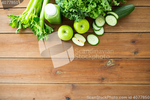 Image of close up of bottle with green juice and vegetables