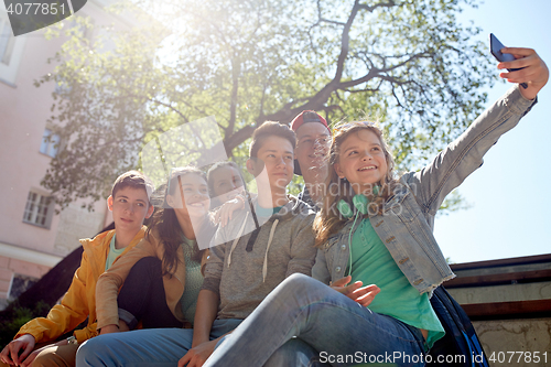 Image of happy teenage students taking selfie by smartphone