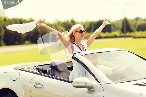 Image of happy man and woman driving in cabriolet car