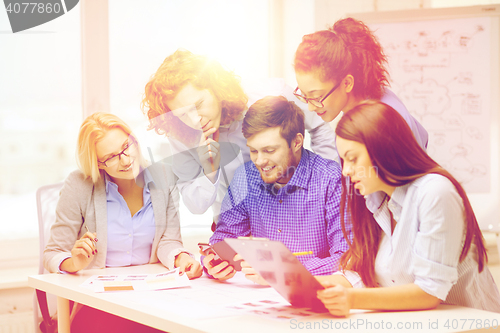 Image of creative team with papers and clipboard at office