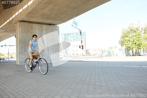 Image of young hipster man riding fixed gear bike