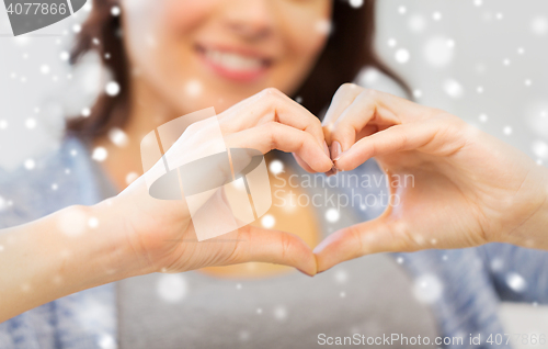 Image of close up of happy woman showing heart with hands