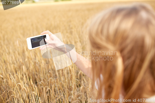 Image of close up of girl with smartphone on cereal field