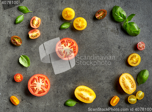 Image of various colorful tomatoes and basil leaves