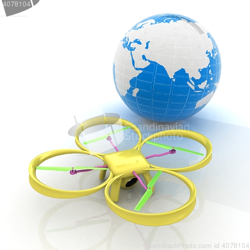 Image of Quadrocopter Drone with Earth Globe and remote controller on a w