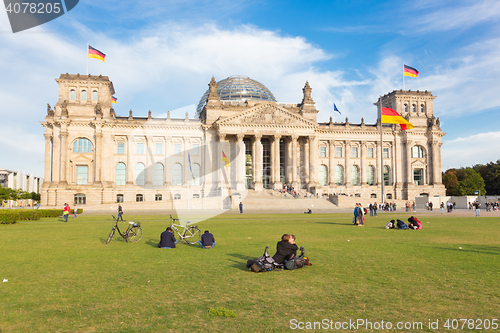 Image of Young couple kissing on a meadow infront of Reichstag building in Berlin, Germany.