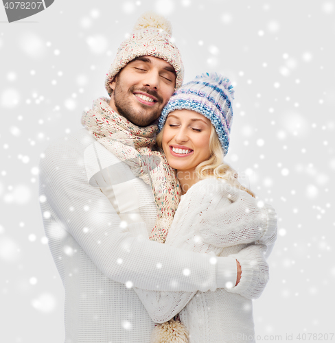 Image of smiling couple in winter clothes hugging