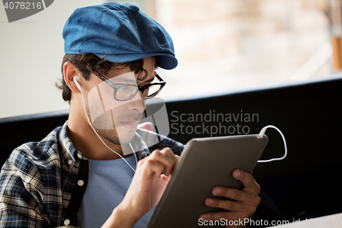 Image of close up of man with tablet pc and earphones