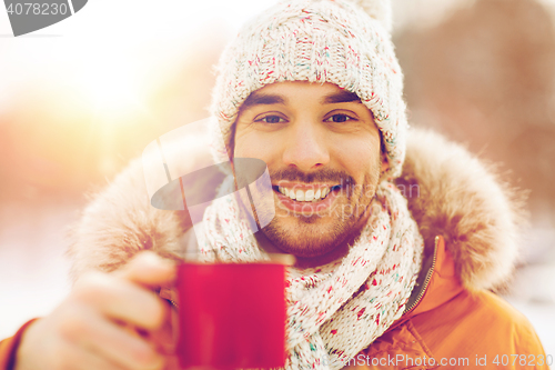 Image of happy man with tea cup outdoors in winter