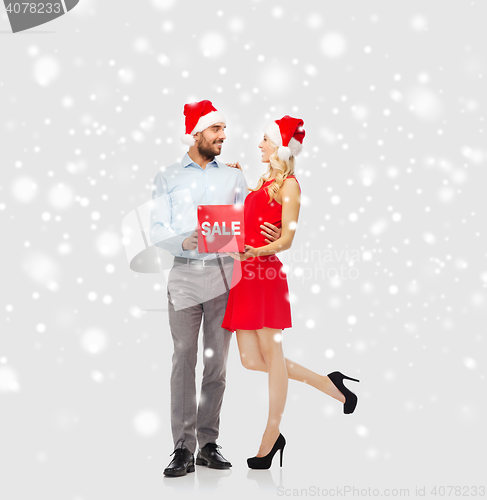 Image of happy couple with red sale sign over snow