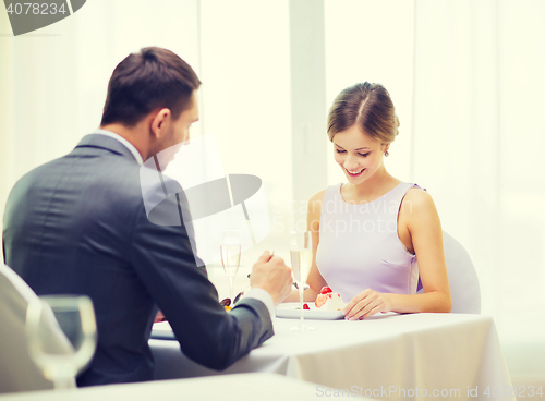 Image of smiling couple eating dessert at restaurant