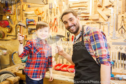 Image of father and son with hammers working at workshop