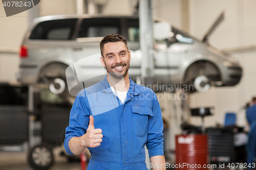 Image of happy auto mechanic man or smith at car workshop