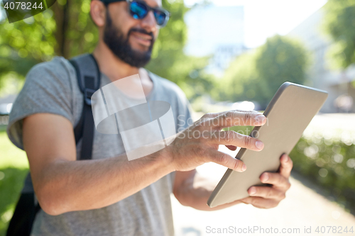 Image of close up of man with tablet pc and bag in city