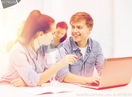 Image of two smiling students with laptop computer