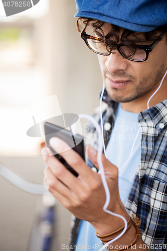 Image of man with earphones and smartphone listening music