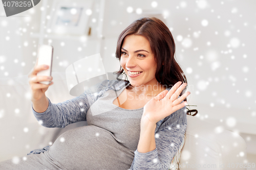 Image of happy pregnant woman with smartphone at home