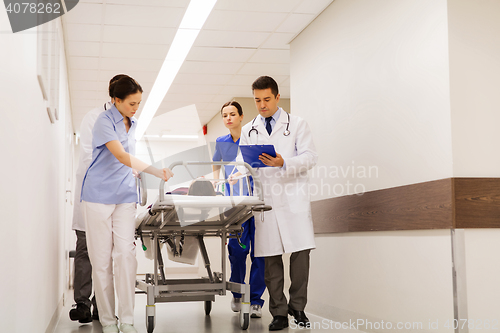 Image of medics with woman on hospital gurney at emergency