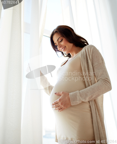 Image of happy pregnant woman with big tummy at home