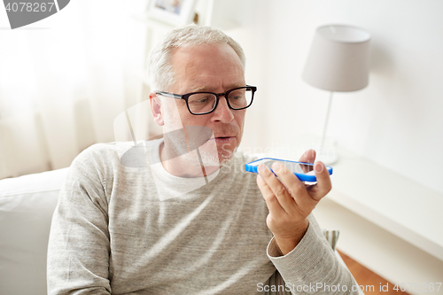 Image of old man using voice command recorder on smartphone