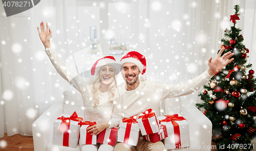 Image of happy couple at home with christmas gift boxes