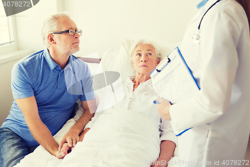 Image of senior woman and doctor with clipboard at hospital