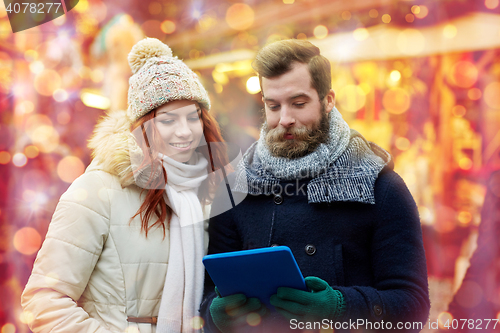 Image of happy couple walking with tablet pc in old town