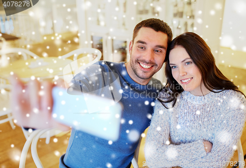 Image of couple taking smartphone selfie at cafe restaurant