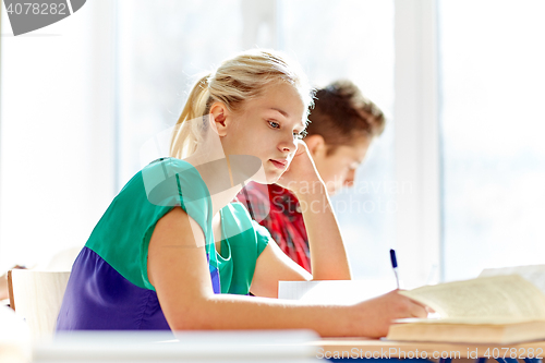 Image of group of students with books writing school test