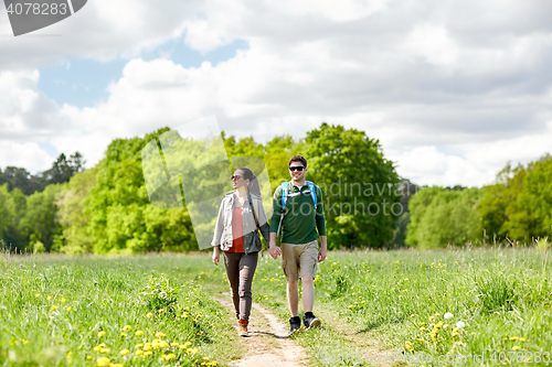 Image of happy couple with backpacks hiking outdoors