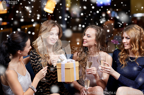 Image of happy women with champagne and gift at night club