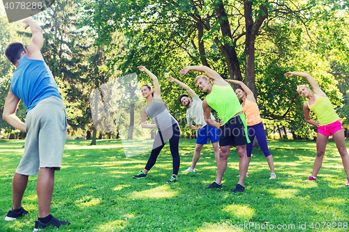 Image of group of friends or sportsmen exercising outdoors