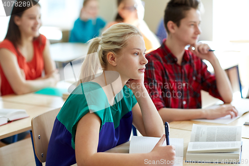 Image of group of students with books writing school test