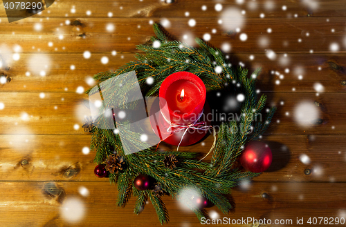 Image of fir branch wreath with candle on wooden table