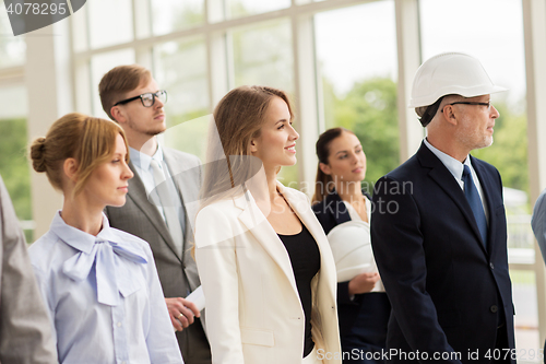 Image of business team in helmets walking along office