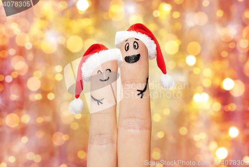 Image of close up of two fingers with smiley and santa hats