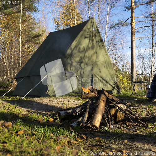 Image of Retro tent in forest and camp fire